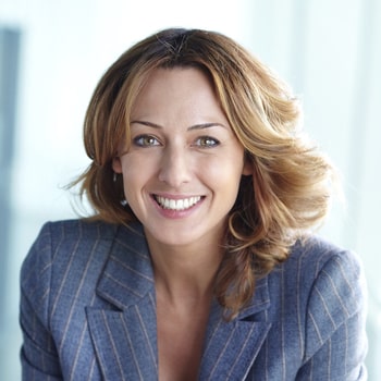A businesswoman smiles to show how dental bridges can close gaps in your smile.