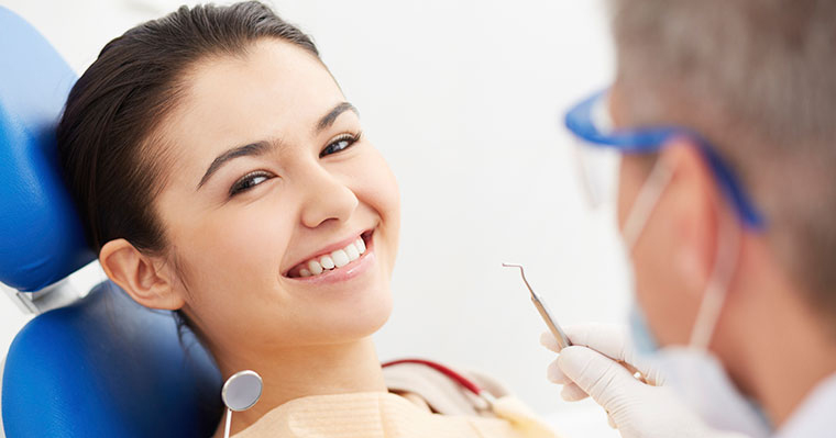 Woman calm and smiling at dentist having solved dental anxiety problems with sedation dentistry